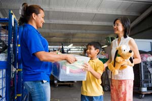 A family donates a bin of clothing at a Goodwill donation site.