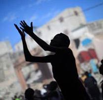 A silhouetted boy with outstretched arms on a street