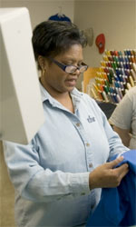 A worker handles fabric at a sewing shop