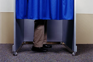 A man behind a curtain in a voting booth