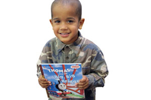 A child smiling while holding a book
