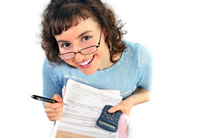 A woman holding tax forms and a calculator