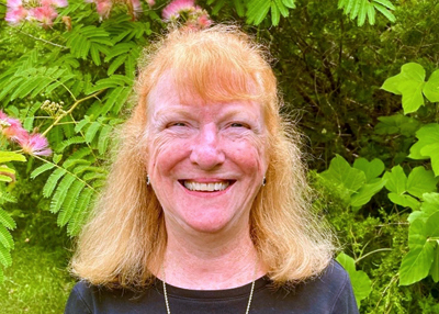 Women wearing a black shirt standing in front of plants