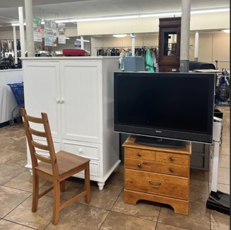 A picture of nightstands, a tv and chairs in a store